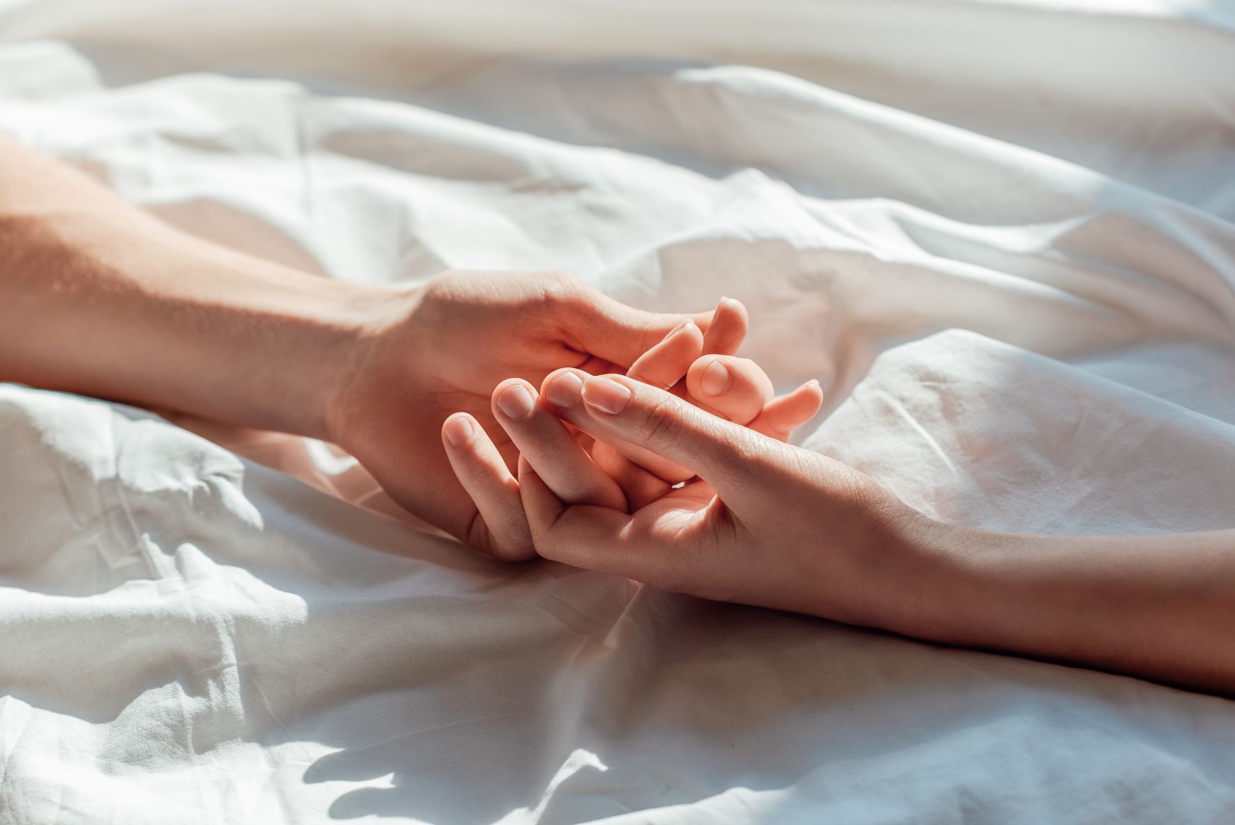 Touching hands on bed